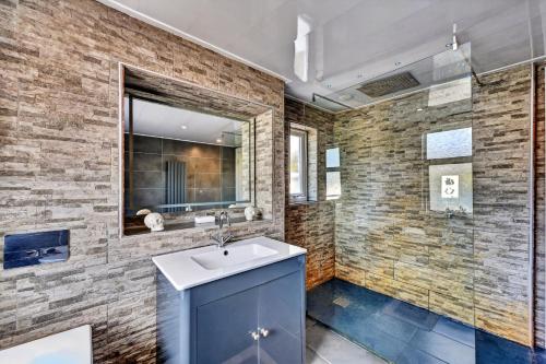 a bathroom with a sink and a brick wall at Finest Retreats - Seamill Beach House in Seamill