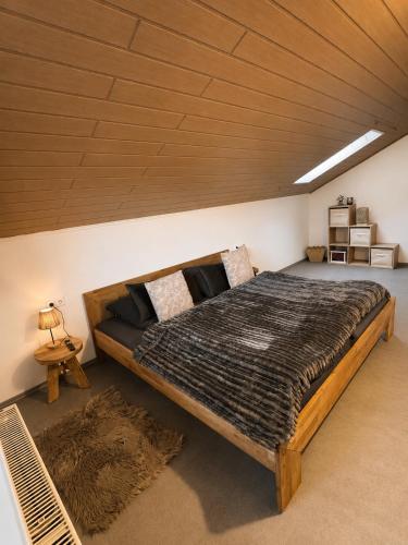 a large bed in a room with a wooden ceiling at Apartment Auszeit in Ulrichstein