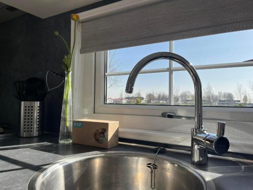 a kitchen counter with a sink and a window at Chaletverhuur-Olmenduin in Serooskerke