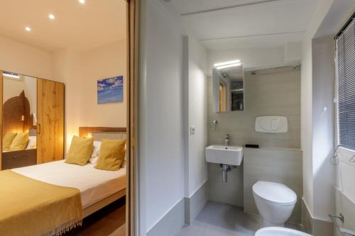 a bathroom with a bed and a toilet and a sink at Rooftop St. Peter in Rome
