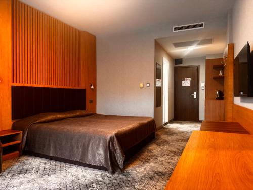 a bedroom with a large bed and a wooden wall at Spa Hotel Ata in Varshets