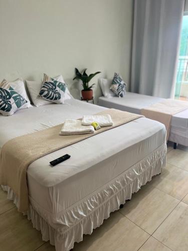 a bed with a remote control on top of it at My House Muriqui in Mangaratiba