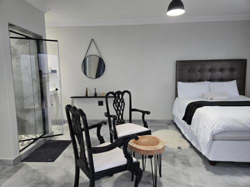 a bedroom with a bed and a table and chairs at Cjabaledi Private Guesthouse in Centurion