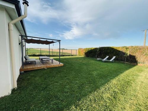 a patio with two chairs and a table on a lawn at Villa Alba in Auménancourt-le-Petit