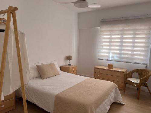 a bedroom with a bed and a window and a chair at 3 Bed Flat - Sleeps 5 - Wifi in Bellreguart