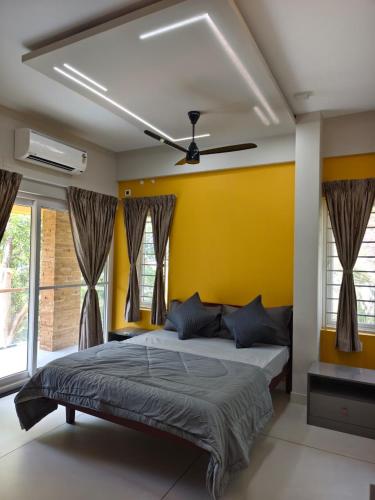 a bedroom with a bed with a yellow wall at G10 & 12 - Sabari Enclave Premium One bedroom Apartment in Trivandrum