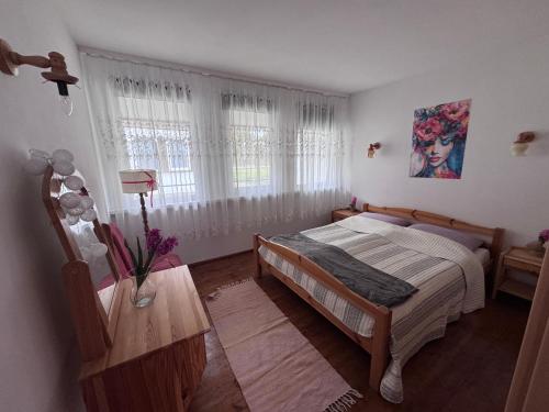 a bedroom with a bed and a window with curtains at Domek Premium in Tleń