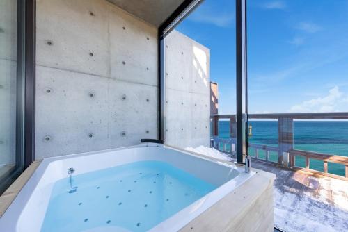 a large bath tub with a view of the ocean at Goseong Romiet Pension in Goseong