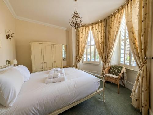 a bedroom with a white bed and two windows at Sandlands - Perfect central location in Ryde