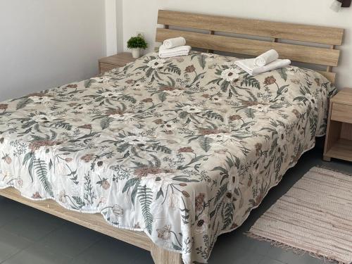 a bedroom with a bed with a floral bedspread at Platanos Rooms in Agia Marina