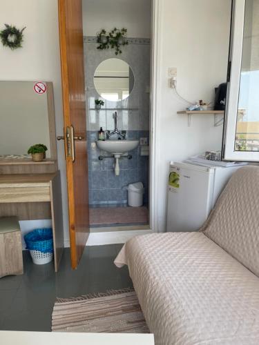 a bathroom with a sink and a shower with a bed at Platanos Rooms in Agia Marina