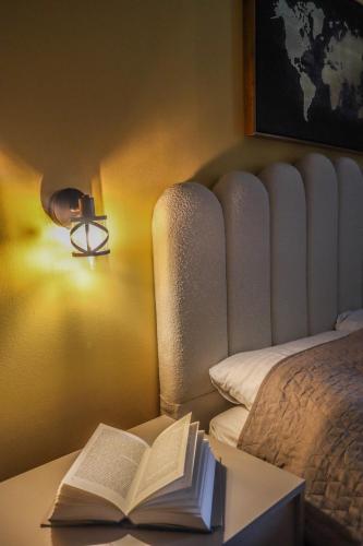 an open book on a desk next to a bed at D&N Adriatic Nest in Kotor