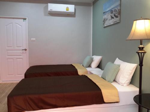 a bedroom with two beds and a couch at Kala Krang Nueng in Ko Samed
