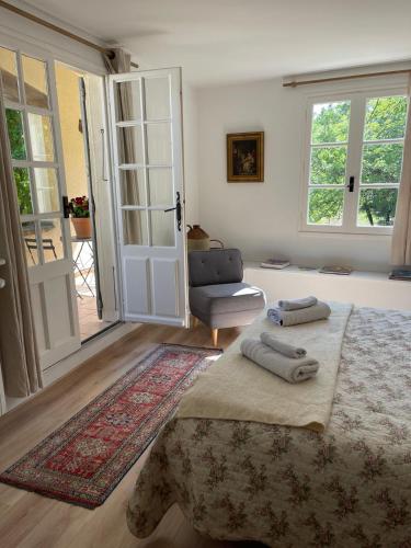 a bedroom with a bed and a chair and a door at La bergerie in Grignan