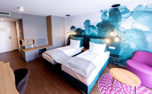 a hotel room with two beds and a couch at DORMERO Hotel Freiburg in Freiburg im Breisgau