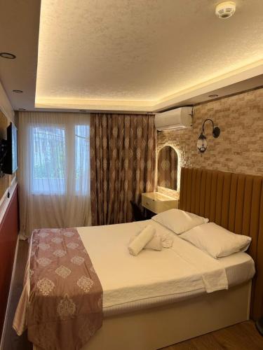 a bedroom with a large bed with white sheets and a window at elisa apart 3 in Istanbul