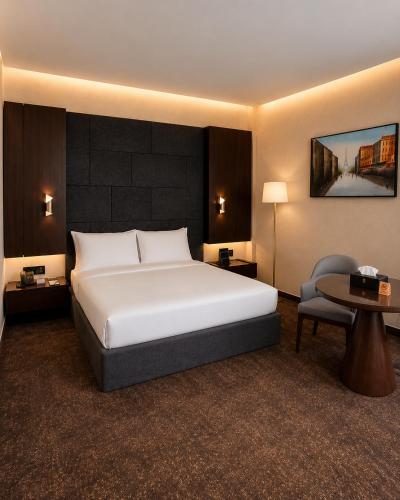 a hotel room with a bed and a chair at Baghdad Do Hotel in Baghdād