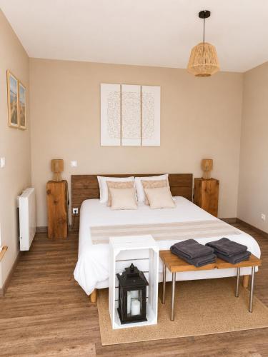 a bedroom with a large white bed and a table at Chez Elise et Joseph in Mons-Boubert