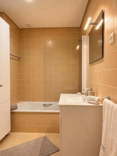 a bathroom with a tub and a sink and a bath tubermottermott at Aqua Gerês in Geres