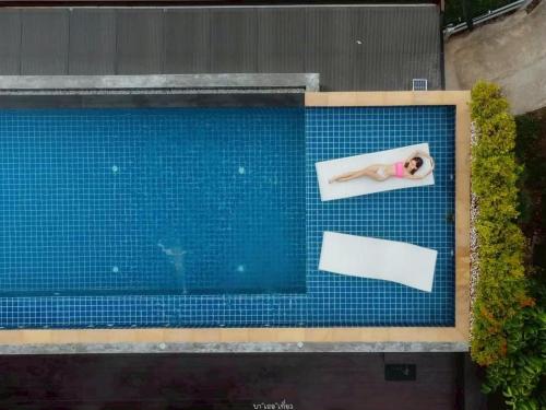 an overhead view of a swimming pool with a person laying on it at Sangthong Resort at Chiang Klang in Chiang Klang