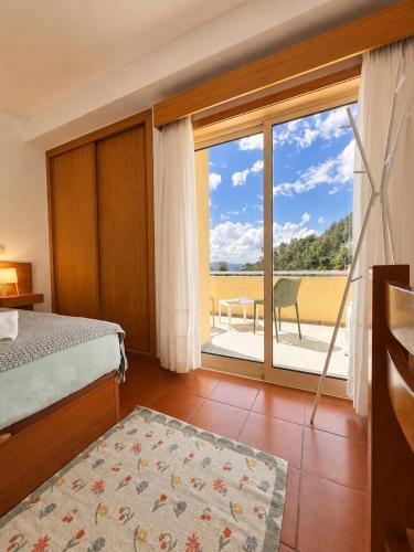 a bedroom with a bed and a large window at Aqua Gerês in Geres