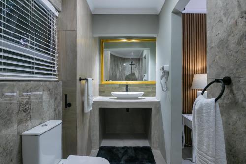 a bathroom with a sink and a toilet at Lagoon Point Lodge in Knysna