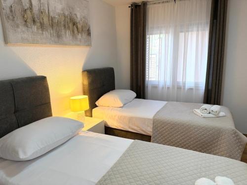 a hotel room with two beds and a window at Villa Orange Peaceful Holiday Retreat in Zadar