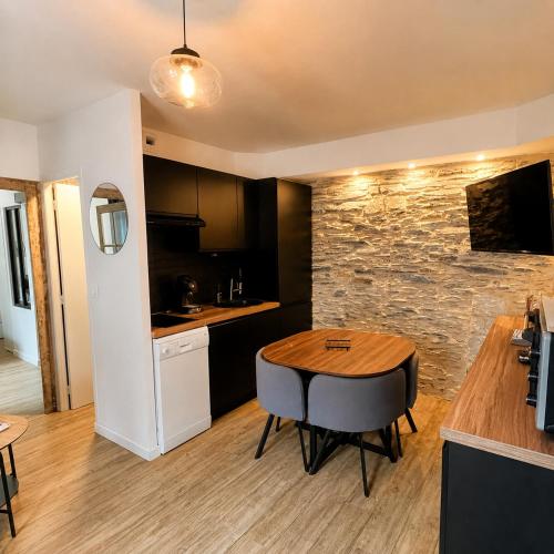 a kitchen and dining room with a table and a counter at Nid douillet cosy au cœur d'Angers, idéal à deux in Angers
