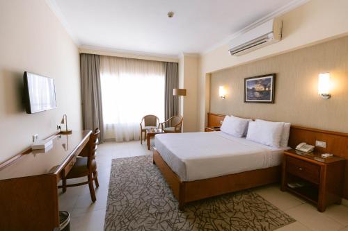 a hotel room with a bed and a desk at The Grand Plaza Hotel Smouha in Alexandria