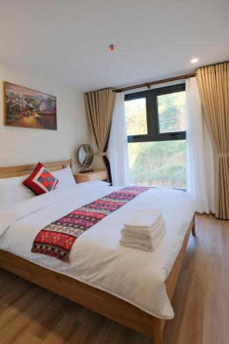 a bedroom with a large bed with a window at Lia Home in Sapa