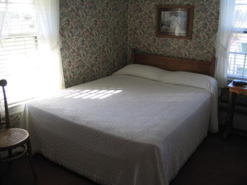 a small bedroom with a bed in a room with a window at Shaw's Hotel & Cottages in Brackley Beach
