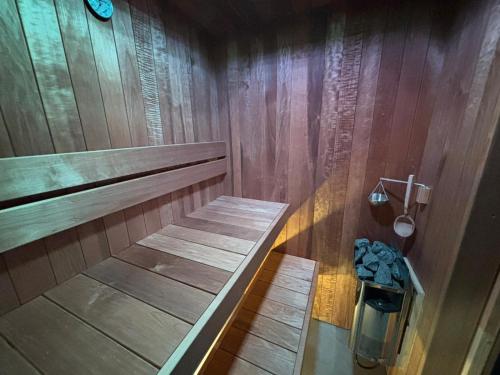 a shower with wooden walls and a wooden bench in a bathroom at Guest House Sidro - Wellness & Restaurant in Selce