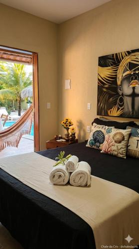 a bedroom with a bed with towels on it at Vila Pescador Fortim in Fortim