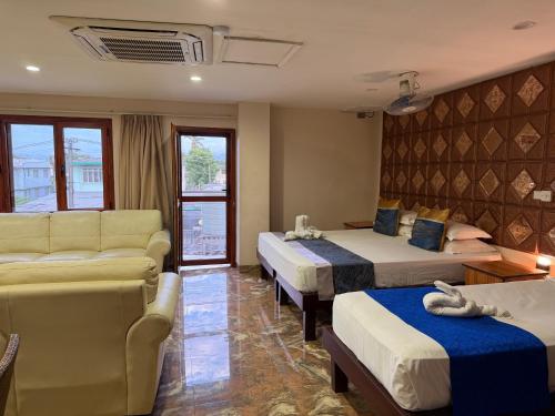 ein Hotelzimmer mit zwei Betten und einer Couch in der Unterkunft Cape Town Hotel in Nadi