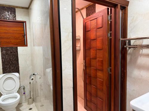 ein Badezimmer mit Toilette und Duschabtrennung aus Glas in der Unterkunft Cape Town Hotel in Nadi