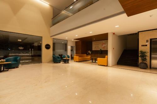 an empty lobby with couches and chairs and a table at Grand Continent Hotel, Rameswaram in Rāmeswaram