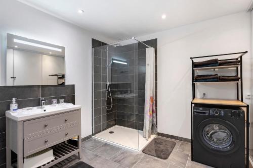 a bathroom with a shower and a washing machine at Le Gîte Des Anges - 4pers, Piscine in Angé