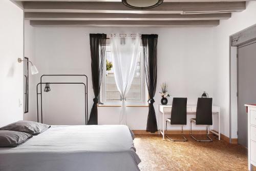 a bedroom with a bed and a desk and a window at Le Gîte des Anges - 12pers, Piscine in Angé