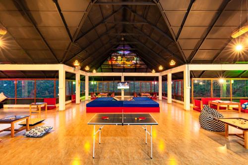 a large room with a table and some chairs at Monkey Tribe Vagamon in Vagamon
