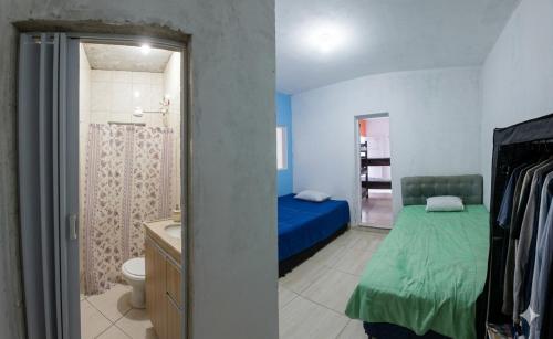 a bedroom with a bed and a bathroom at Espaço Recanto dos Sonhos DR in Itaquaquecetuba