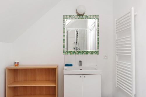 a bathroom with a sink and a mirror at Le Gîte des Anges - 12pers, Piscine in Angé