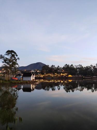 a view of a lake with a house and trees at Bliss 10 people in Palayangan