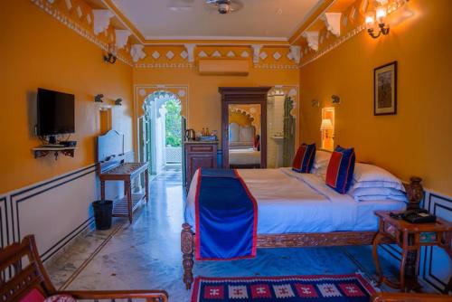 a bedroom with a large bed and a television at Amet Haveli - A Heritage Hotel Udaipur in Udaipur