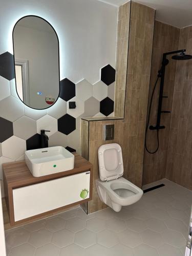 a bathroom with a toilet and a sink and a mirror at Вила Фамилия - Villa Family in Lozenets
