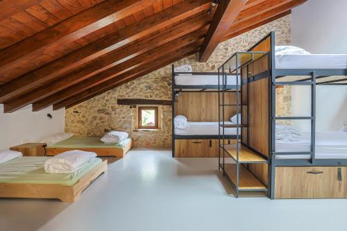 a room with three bunk beds and a wooden ceiling at Olabe hostel in Ea