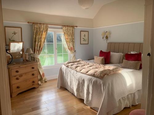 a bedroom with a large bed and a window at Foxhill House in Ledbury