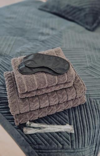 a pile of towels sitting on top of a bed at Sunset Apartment Aktau Квартира в центре у моря in Aktau