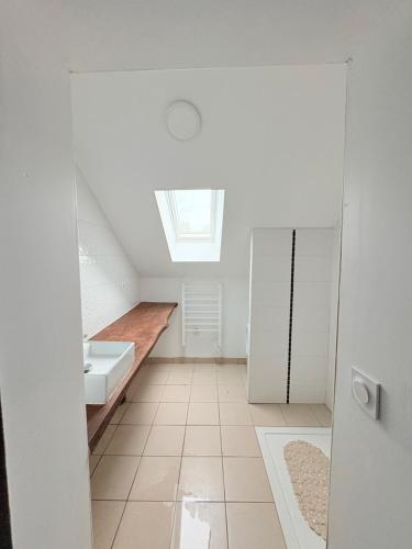 a bathroom with a sink and a skylight at Charmant gite en pierre in Gratot