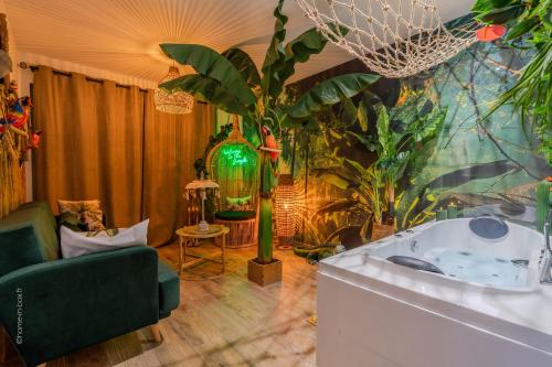 a living room with a bath tub and plants at Lodge de la Jungle avec Spa in Nanteuil-lès-Meaux