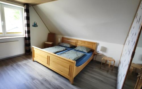 a bedroom with a wooden bed in a attic at 4 Sterne Ferien Martens in Cuxhaven